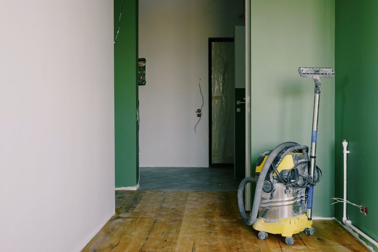 Mastering the First Impression: Your intriguing post title goes here Industrial vacuum cleaner placed on dirty parquet in room with green walls and doorway in spacious apartment during repair works